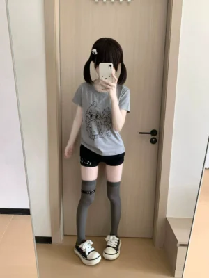 Side profile mirror selfie of heather gray yami kawaii anime print t-shirt, alternate angle showing crew neck and print clarity on model with twin-tailed hairstyle