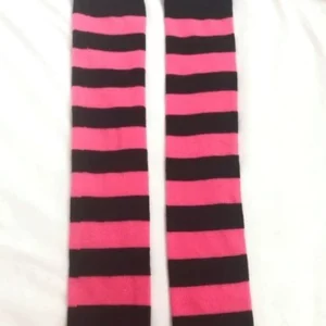 Hot pink and black striped over-the-knee socks flat lay detail view, alternating horizontal stripes, white background