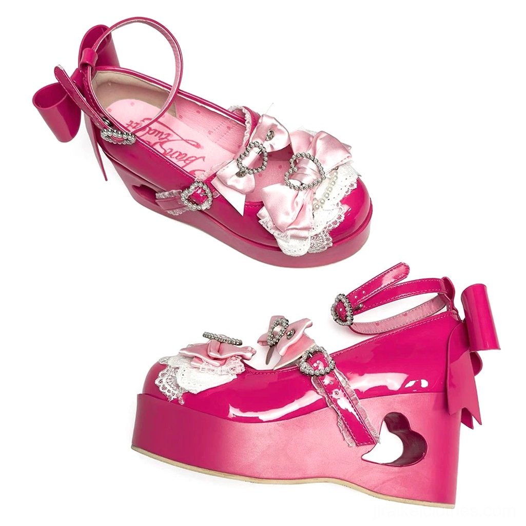 Hot pink magenta Jirai Kei platform Mary Jane shoe featuring satin bow trim, rhinestone buckles, and heart-cutout heel three-quarter angle