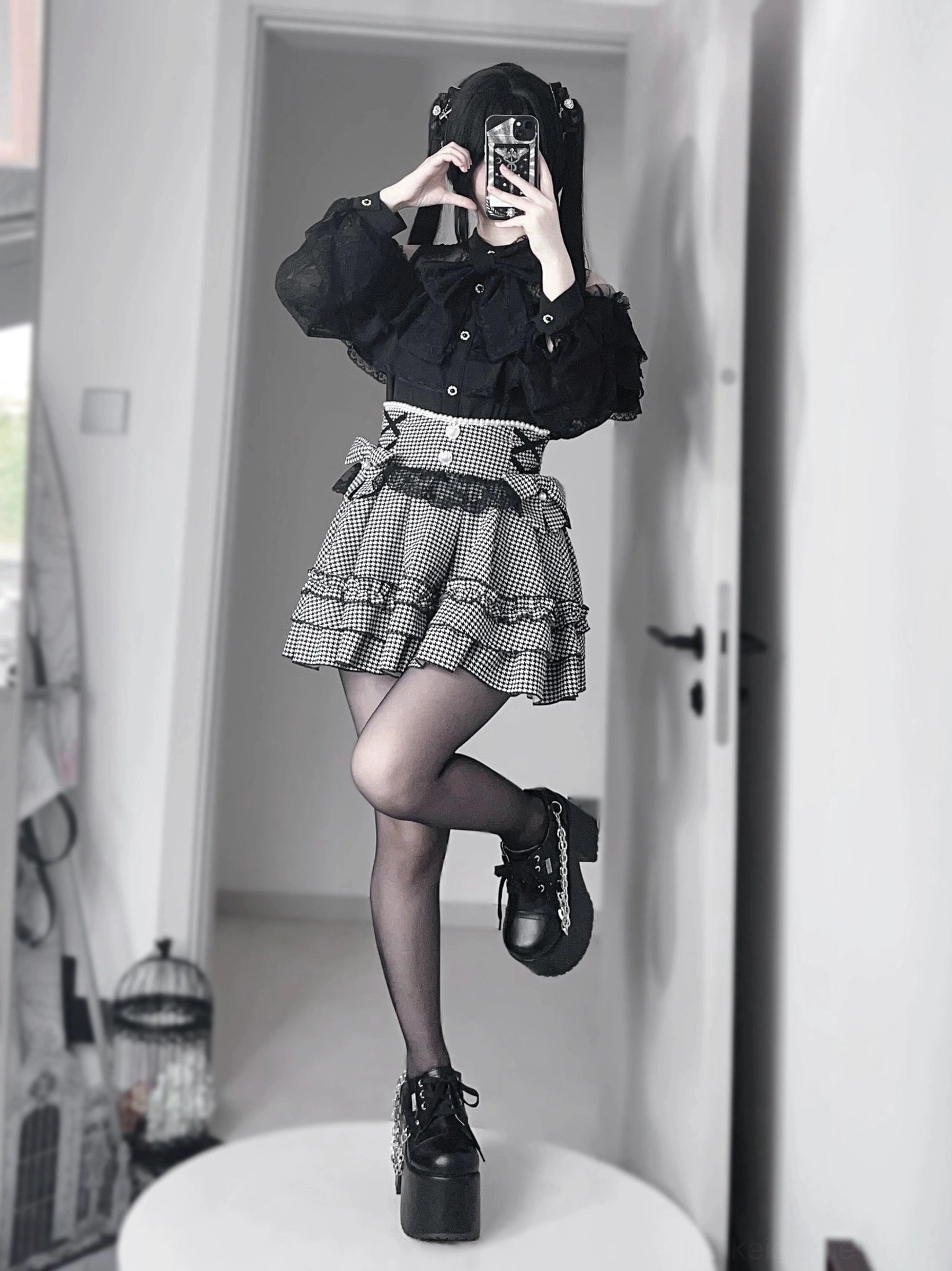 Houndstooth jirai kei ruffle skirt with black lace blouse, side mirror selfie showing sheer tights and platform loafers, hooded styled model