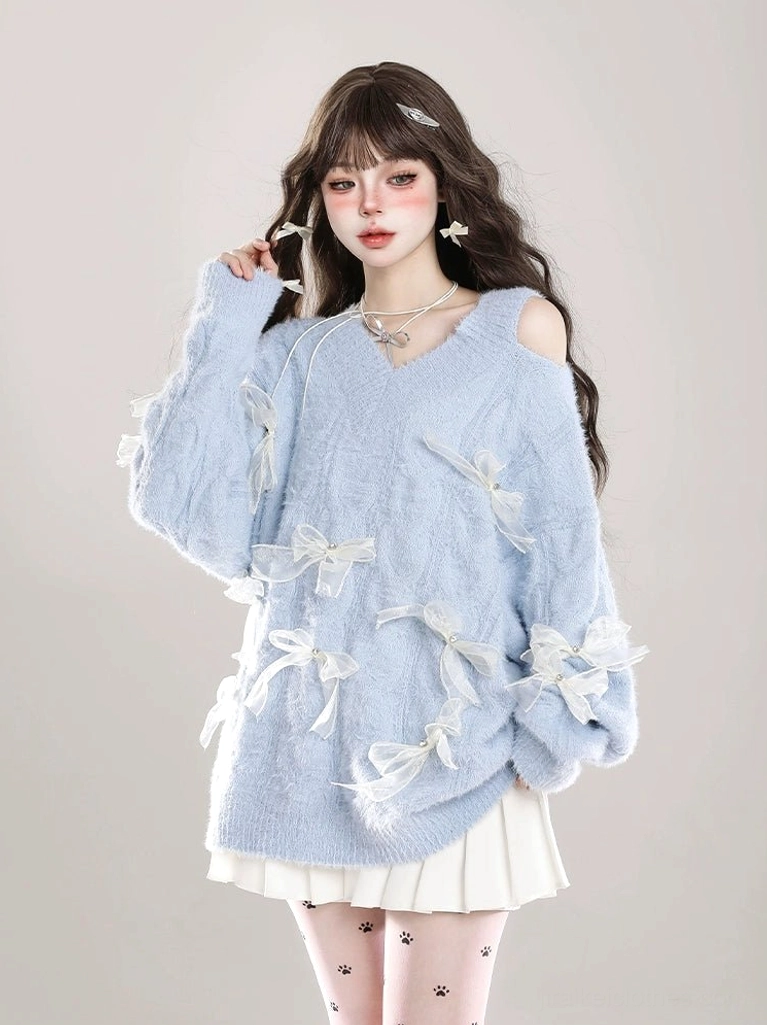Baby blue Jirai Kei cold-shoulder sweater with delicate white ribbon bows, soft fuzzy knit texture, V-neck design, paired with pleated skirt and printed tights, three-quarter angle view