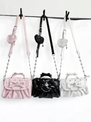 Jirai Kei crossbody bags hanging flat view on clothing rack with detachable heart-shaped charm bags and rhinestone chain shoulder straps visible