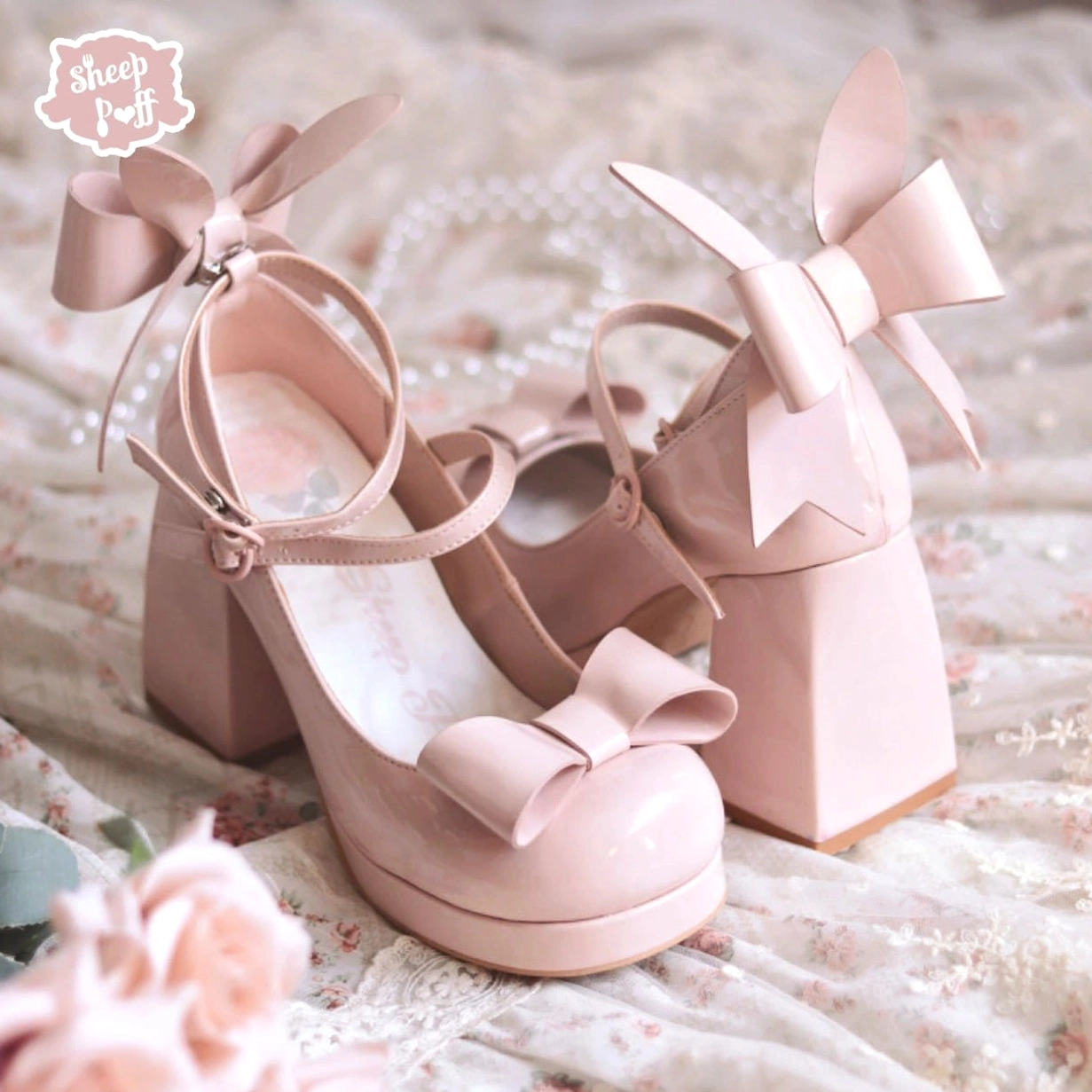 Barbie pink patent leather Jirai Kei platform heels on floral lace fabric showing glossy finish back ankle bow and block heel construction