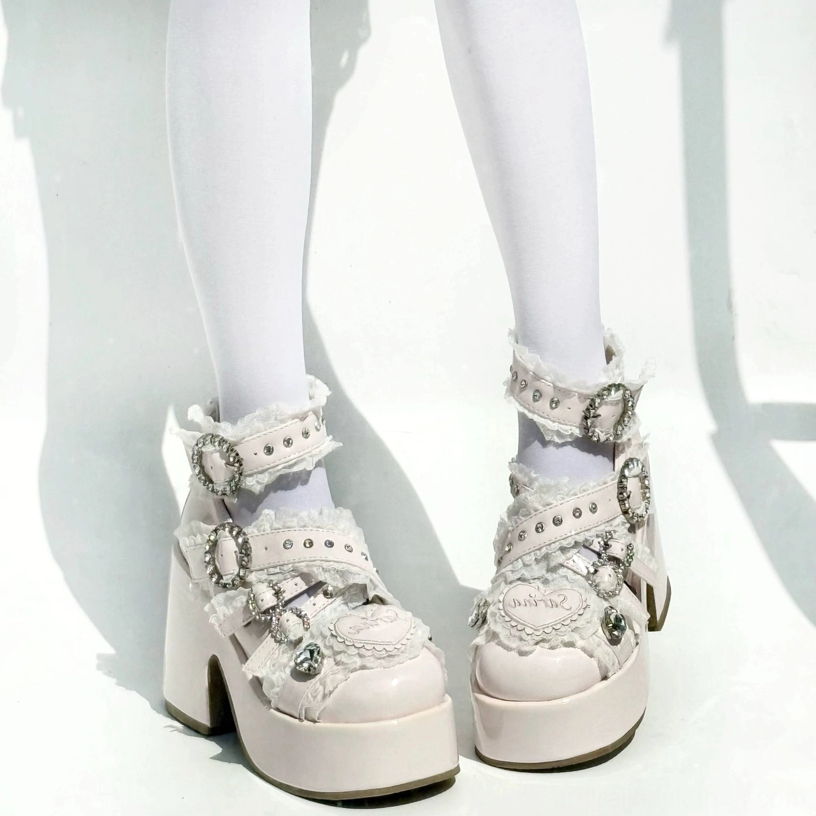 Light beige Jirai Kei platform heels with ruffled lace crystal hardware multiple buckles on model