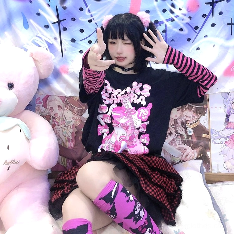Half-body front pose of black-base pink-purple striped false two-piece jirai kei punk tee with anime character graphic print and bangs hairstyle