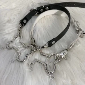 Black Jirai Kei bone and star pendant PU choker necklace top-down view with silver metal hardware on white faux fur backdrop