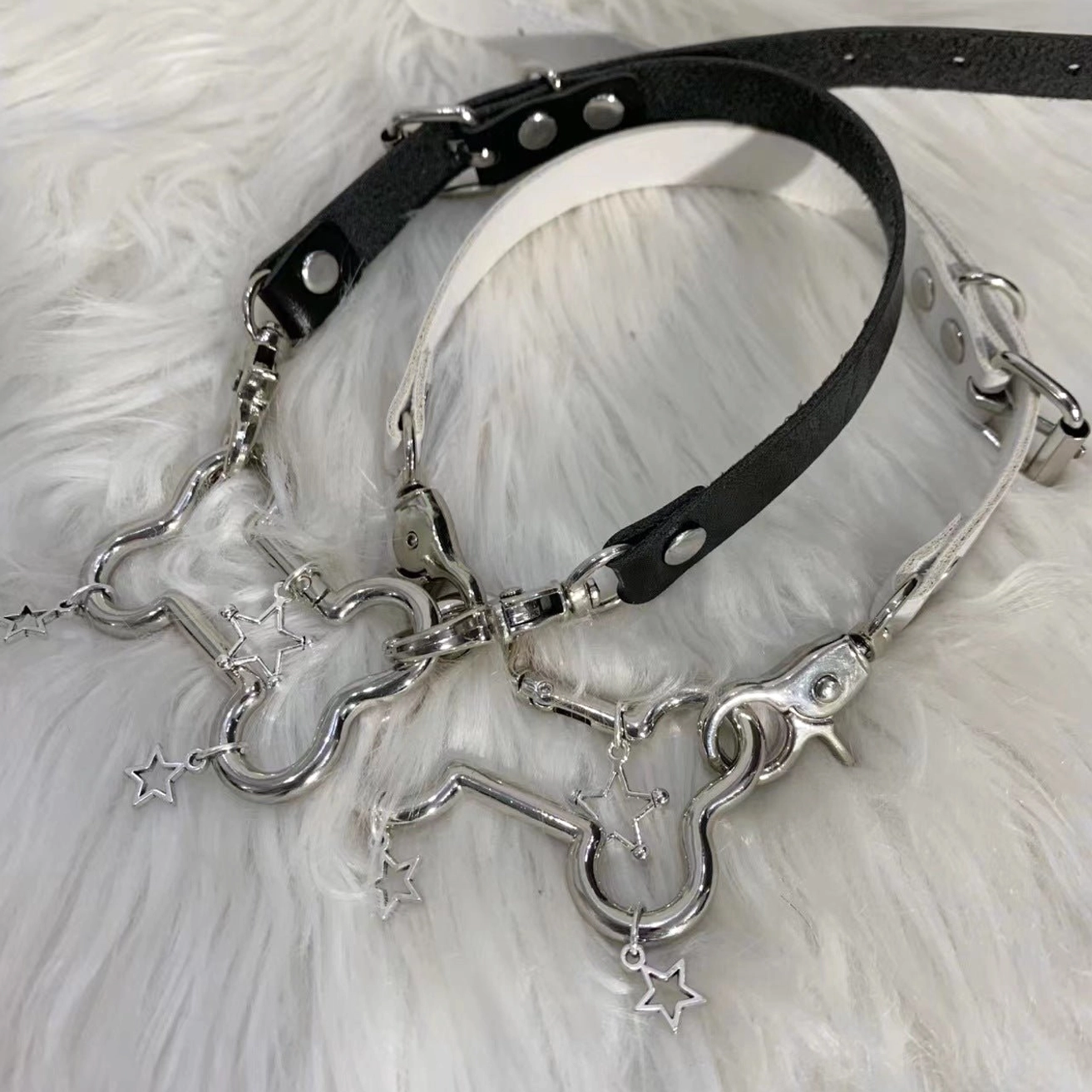 Black Jirai Kei bone and star pendant PU choker necklace top-down view with silver metal hardware on white faux fur backdrop