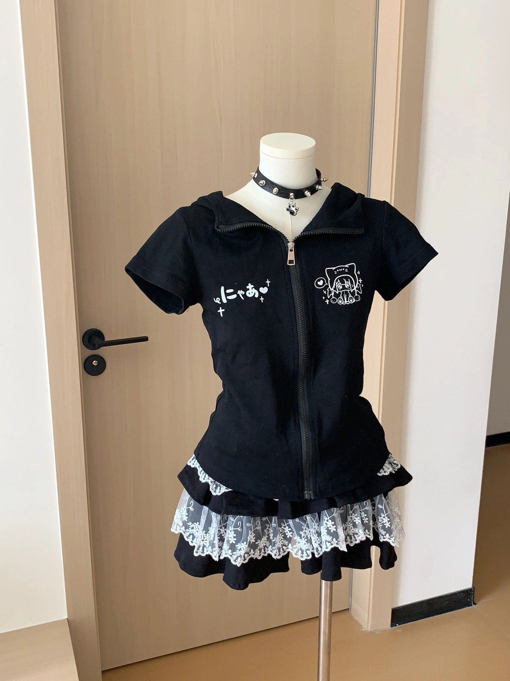 Black zip-up crop hoodie with bunny ears and black lace tiered cake skirt displayed on dress form with black choker accessory front view