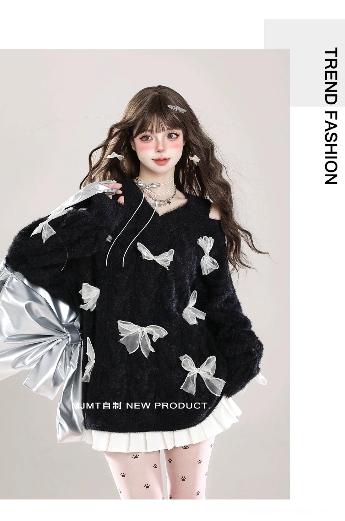 Side three-quarter profile of black Jirai Kei fuzzy bow sweater with white ribbon bows, cold-shoulder design, worn with pleated skirt and patterned tights, styled with silver handbag accessory