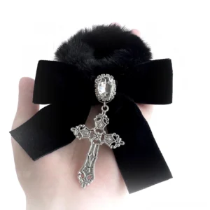 Black fluffy velvet pompom hair tie with vintage cross pendant and rhinestone charm displayed in hand, showing intricate craftsmanship and sparkle details