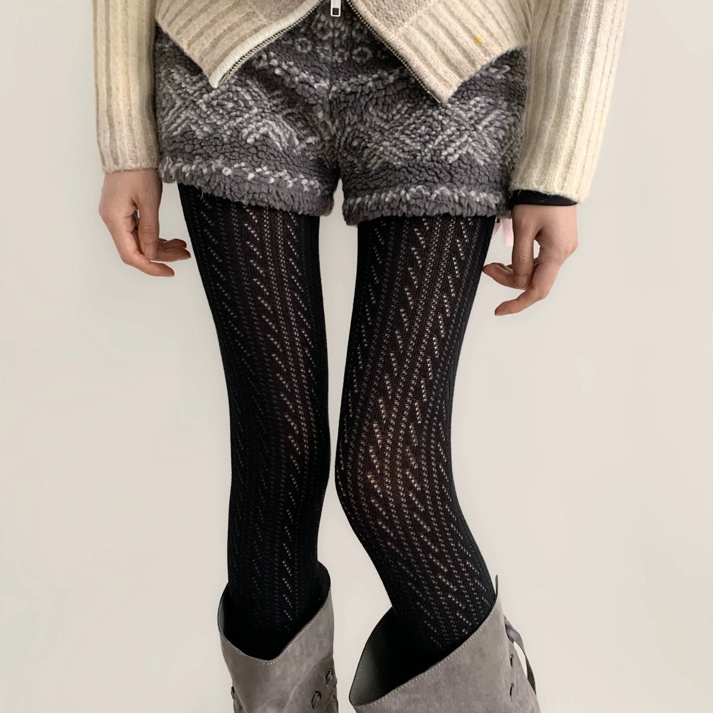 Black Jirai Kei hollow vertical stripe knit tights close-up with patterned fuzzy shorts and gray suede boots
