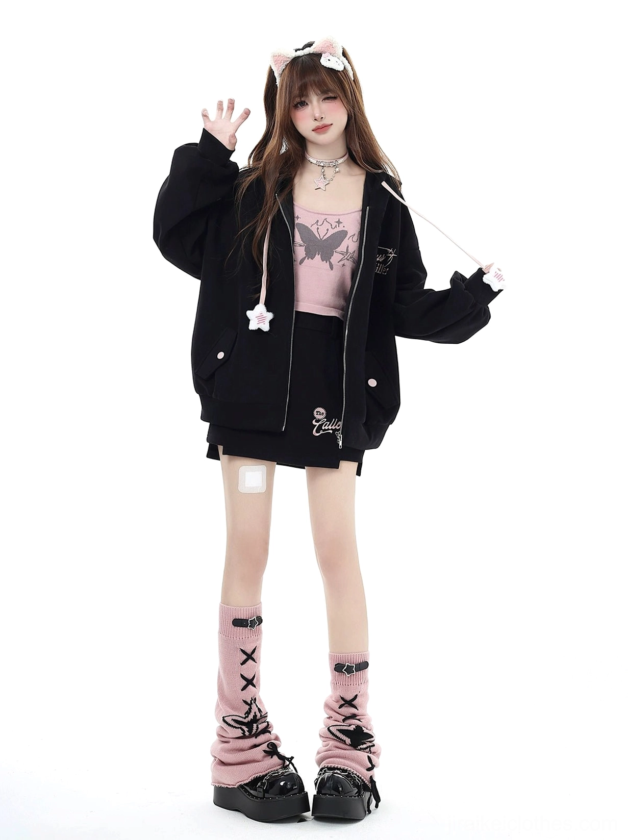 Black Jirai Kei hoodie with band-aid leg decoration and pink butterfly-print camisole visible, star drawstring accents, full-body front