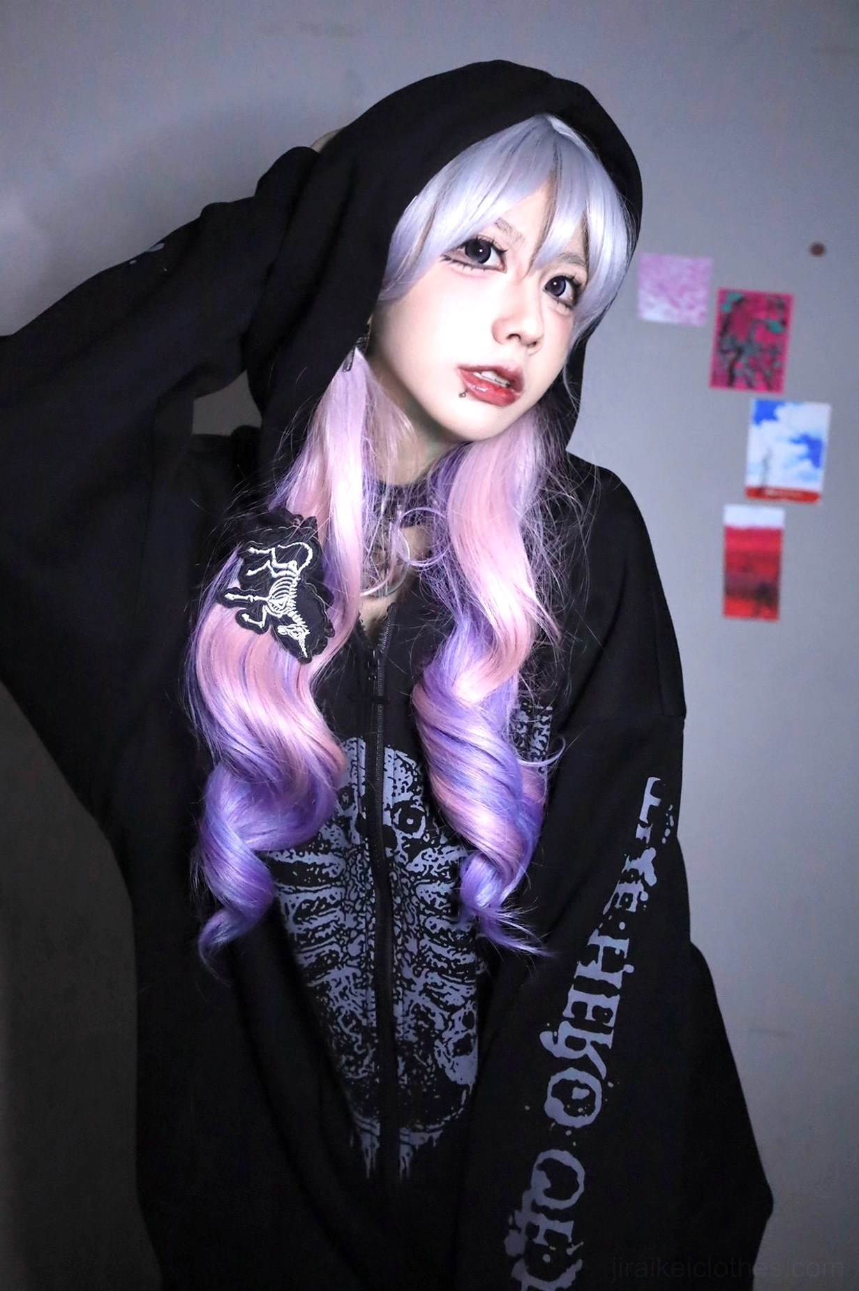 Jirai Kei black gothic hoodie on model with purple ombre hair and hood up, indoor poster background, showcasing bone print design and punk aesthetic