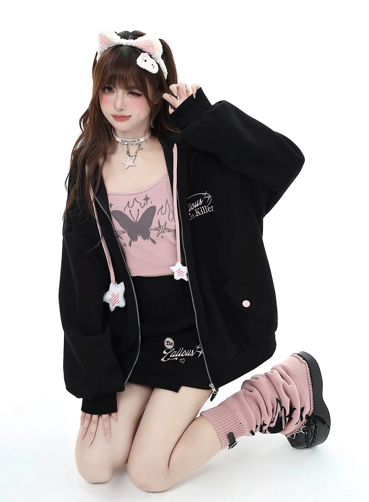 Black Jirai Kei zip-up hoodie with pink butterfly-print camisole, star drawstring accents, and coordinating mini skirt, kneeling front view