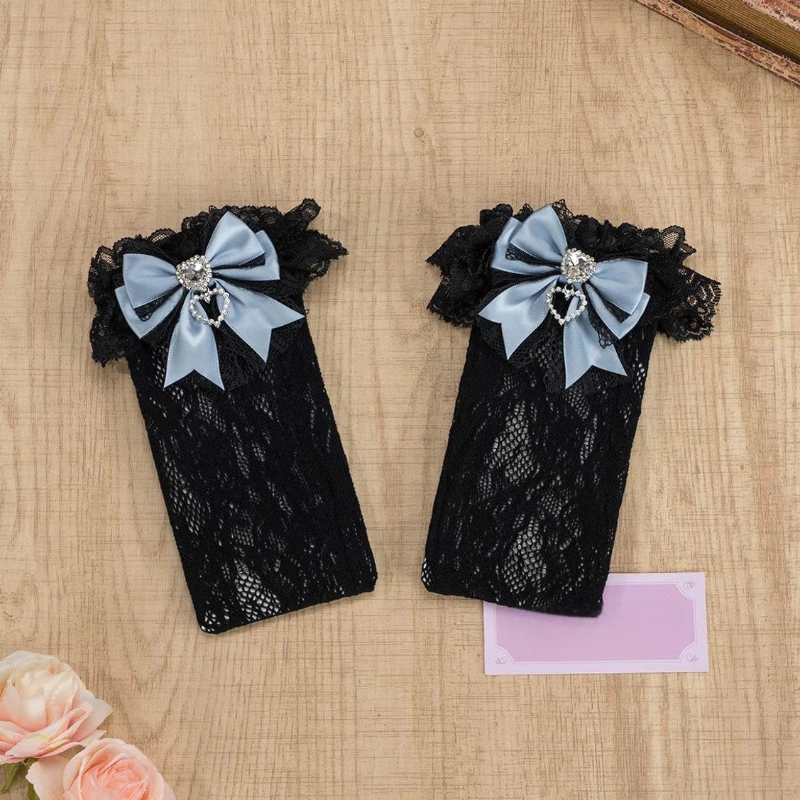 Black lace knee-high Jirai Kei socks with contrasting cuff ruffles, black bow and heart rhinestone detail, full length leg display
