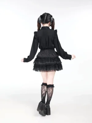 Black Jirai Kei blouse back view showing ruffled yoke design and long tailored sleeves on model wearing lace stockings