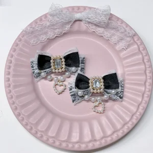 Black lace satin Jirai Kei hair clips with rectangular rhinestones pearl chain heart pendants on pink embossed ceramic plate