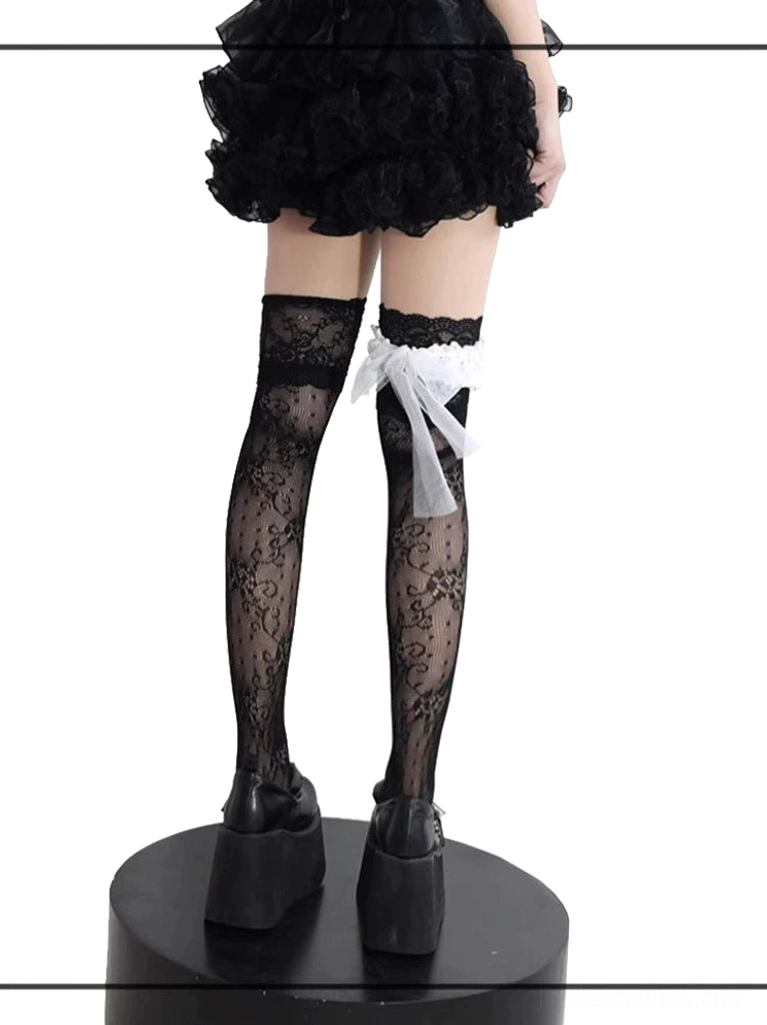 Black floral lace Jirai Kei stockings back view showcasing white ruffled bow garter, paired with platform shoes and ruffled skirt