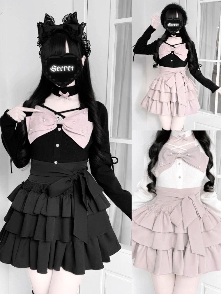 Black Jirai Kei outfit on female model with pink chest bow tiered skirt and cat ear hair accessory split front partial side view