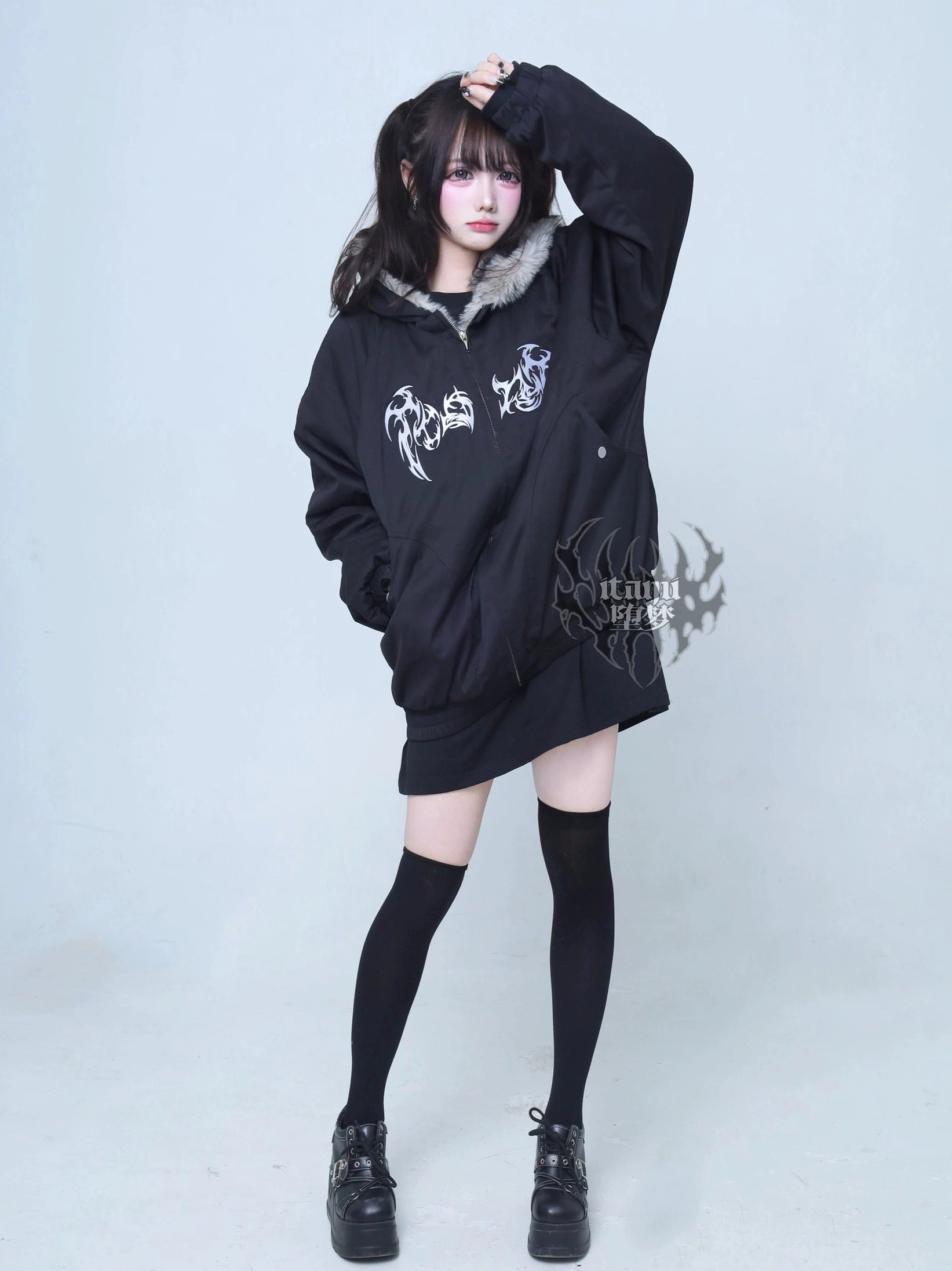 Jirai Kei gothic black padded jacket side front view model posing with hand on hair grey faux fur hood black thigh-high socks loafers