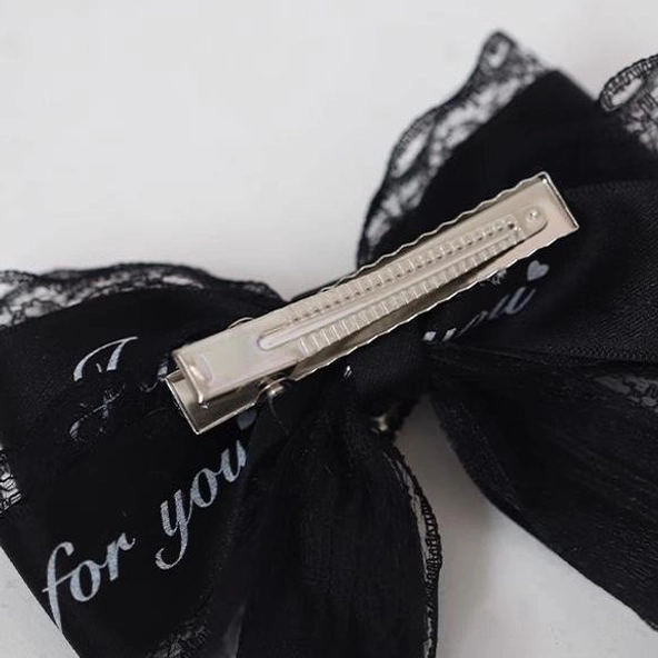Black-pink letter Jirai Kei hair clip with medium bow silhouette, typographic elements, lace trim and heart charm for asymmetrical styling