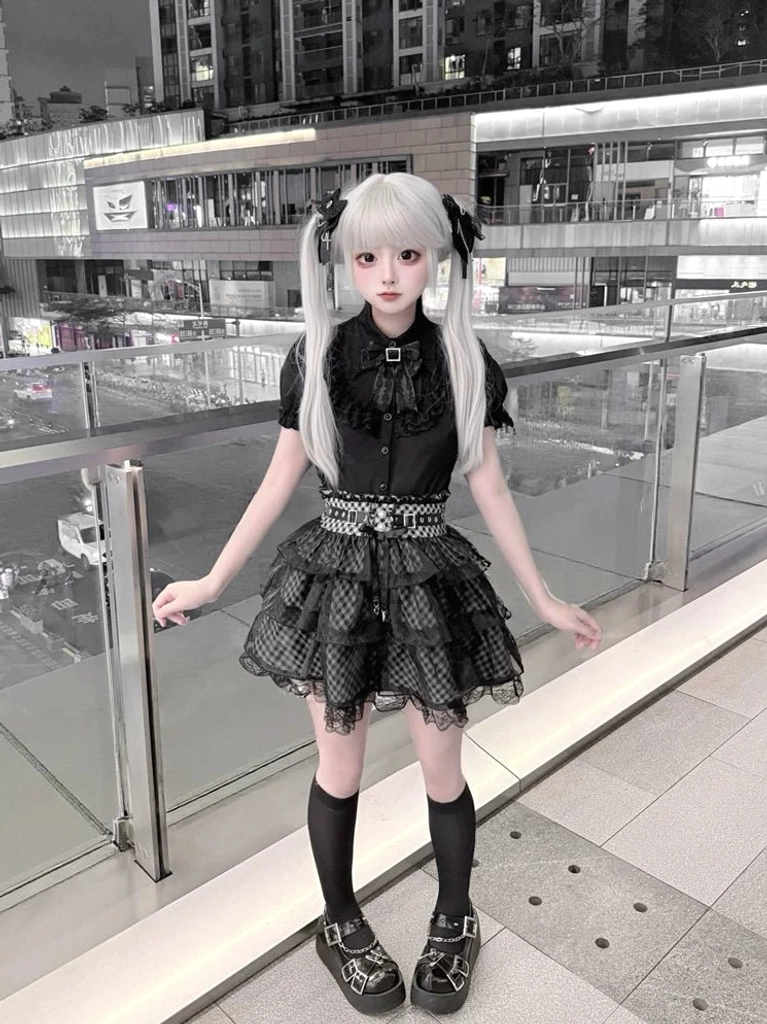 Jirai Kei black blouse plaid skirt side front full-body view relaxed standing pose showing clear layered tulle skirt construction urban setting