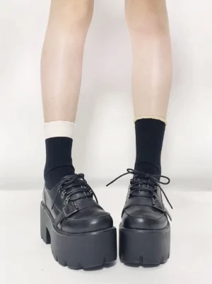 Jirai Kei black platform derby shoes front view showing lace-up design chunky sole and round toe profile worn with mixed black and white socks