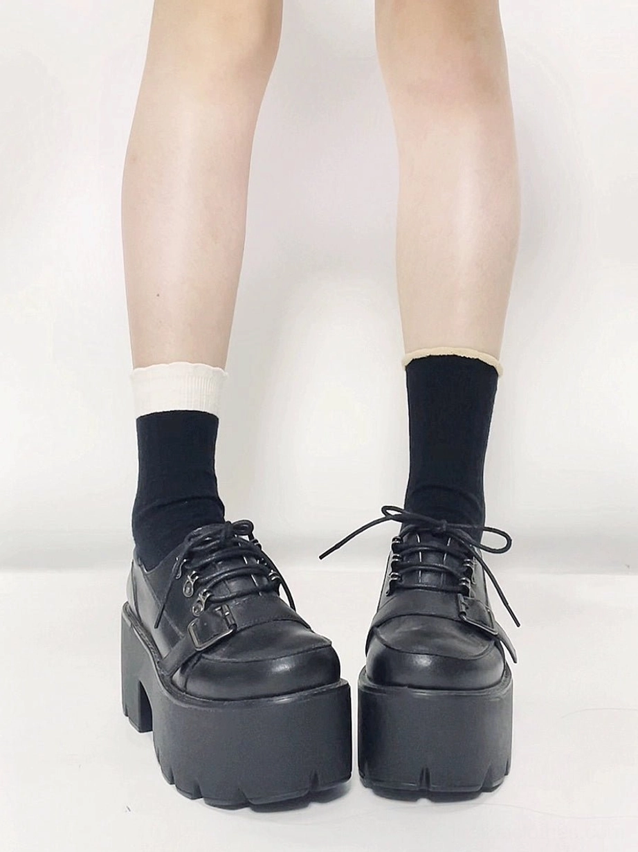 Jirai Kei black platform derby shoes front view showing lace-up design chunky sole and round toe profile worn with mixed black and white socks