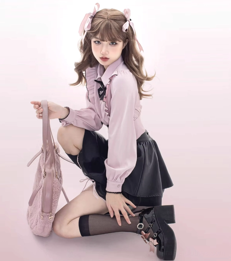 Kneeling pose of female lolita model wearing black platform shoes with pink bow embellishment, holding pink tote bag and matching styling