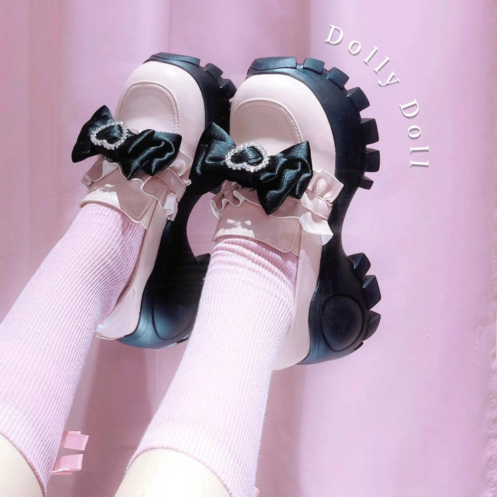 Low-angle model shot of black JK platform shoes with detachable heart rhinestone bow, thick sole, styled with ruffled white knee-high socks