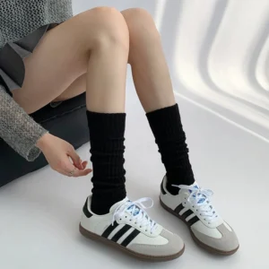 Black ribbed mid-calf Jirai Kei socks with vertical stacked texture worn with retro sneakers for alternative Japanese fashion look