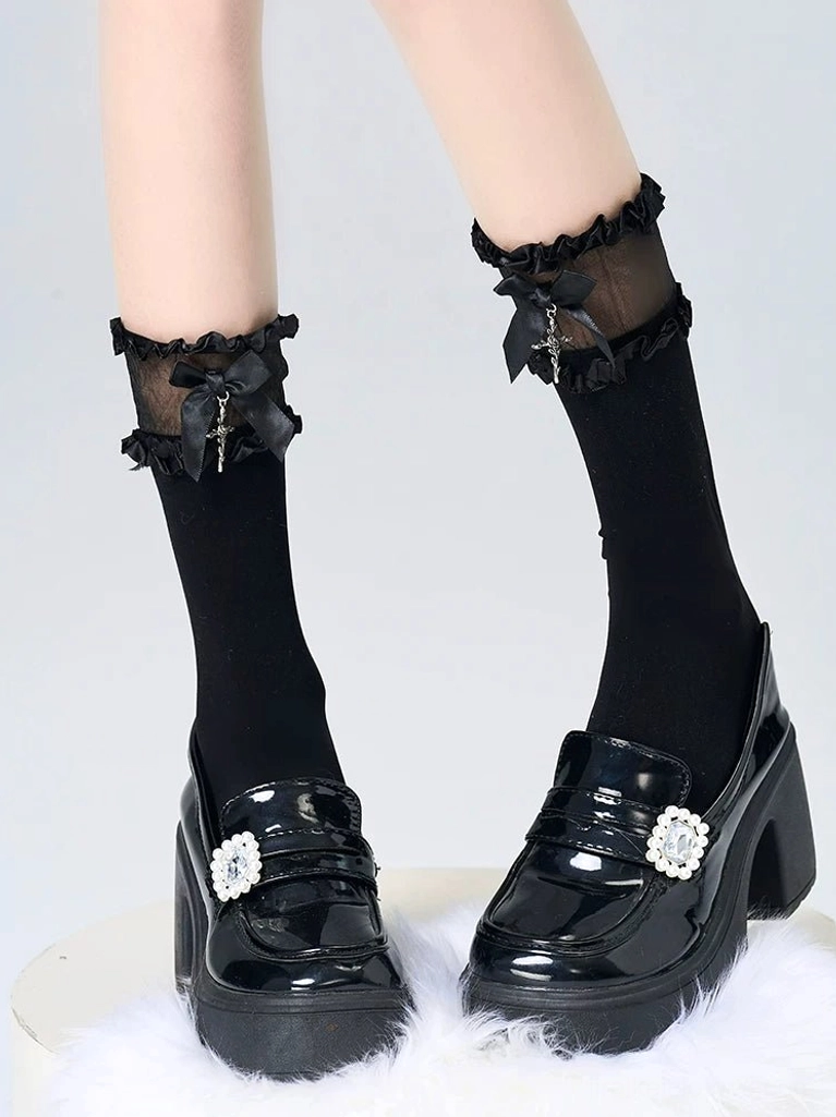 Black short ankle Jirai Kei socks with double-layer ruffled cuff detail paired with black Mary Jane loafers on plain background