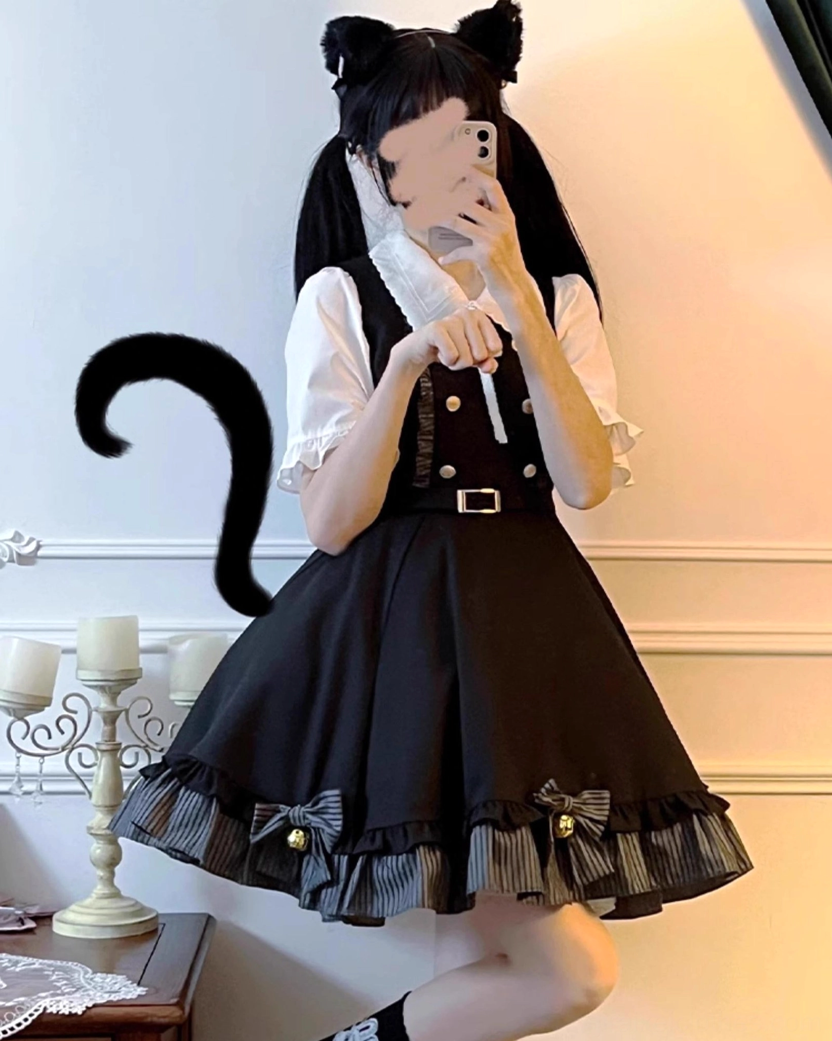 Jirai Kei school uniform set mirror selfie half-body shot of girl wearing black suspender skirt with bow bells on hem and white ruffled blouse, cat ear hair clips, candle holder background