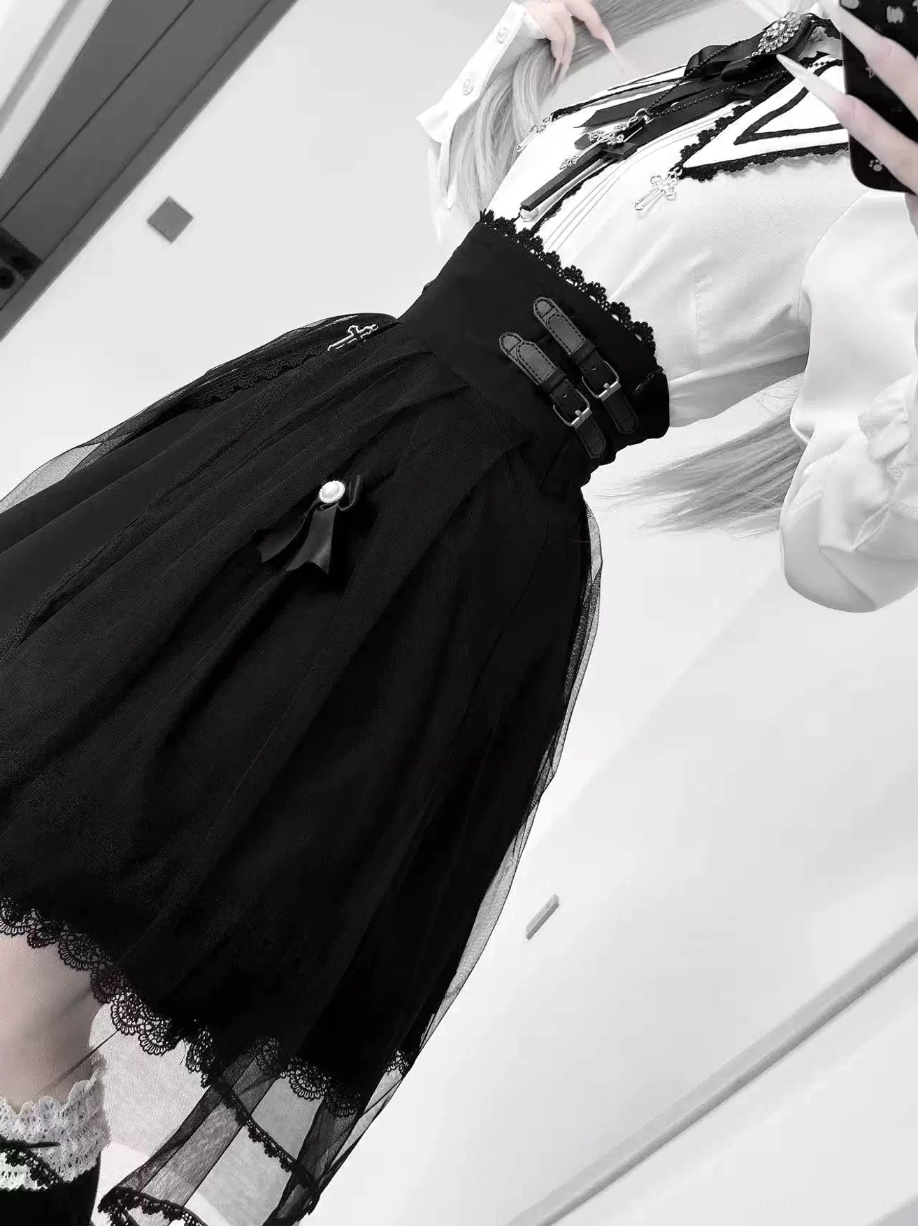 Close-up waist and hip detail of Jirai Kei black high-waist skirt featuring white blouse, decorative bow at waist, tulle hem layer, and metal buckle hardware styling