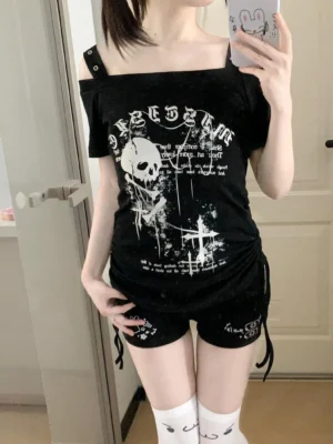 Black gothic skull print Jirai Kei off-shoulder t-shirt with side drawstring worn by model in home setting, front view
