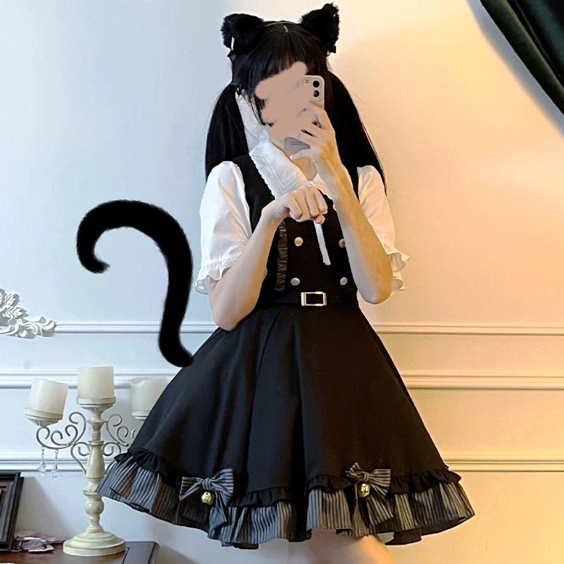 Half-body mirror selfie of complete Jirai Kei preppy uniform set showing black suspender skirt with gold buttons and white ruffled blouse, simple indoor wall background