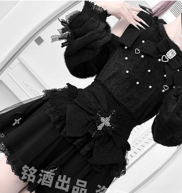 Close-up partial product shot of black fuzzy Jirai Kei sweater showing heart pearl ornaments, removable bow trim, and ruffle cuff details, textile quality showcase