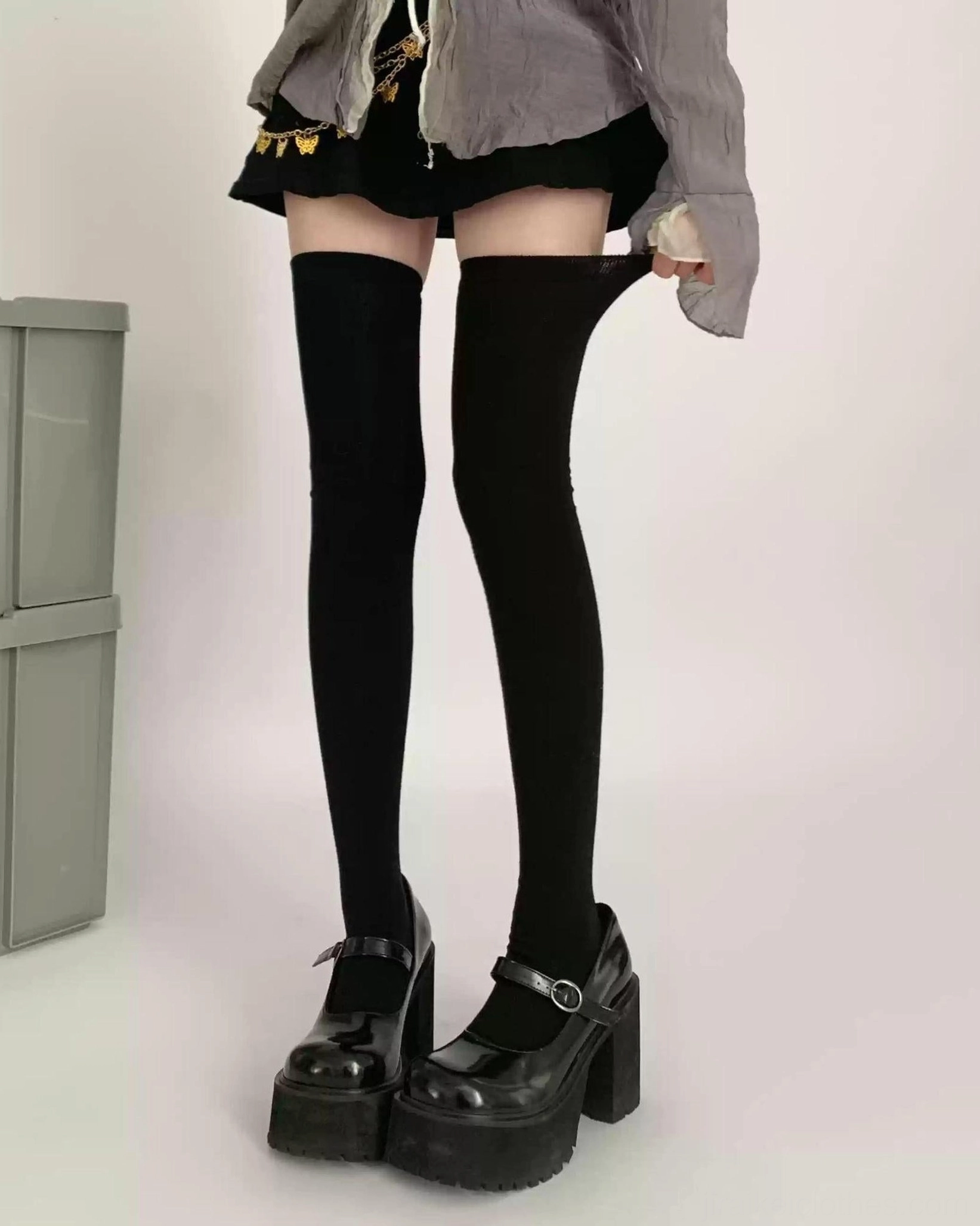 Jirai Kei black thigh-high socks side full-body shot cropped black top pleated skirt black loafers red door background