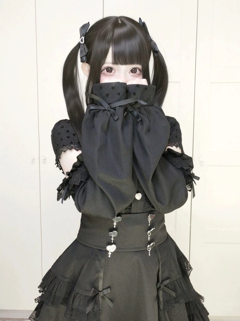 Black Jirai Kei lolita tiered ruffled skirt front view model with hands near face wearing bubble cuff sleeves dark aesthetic