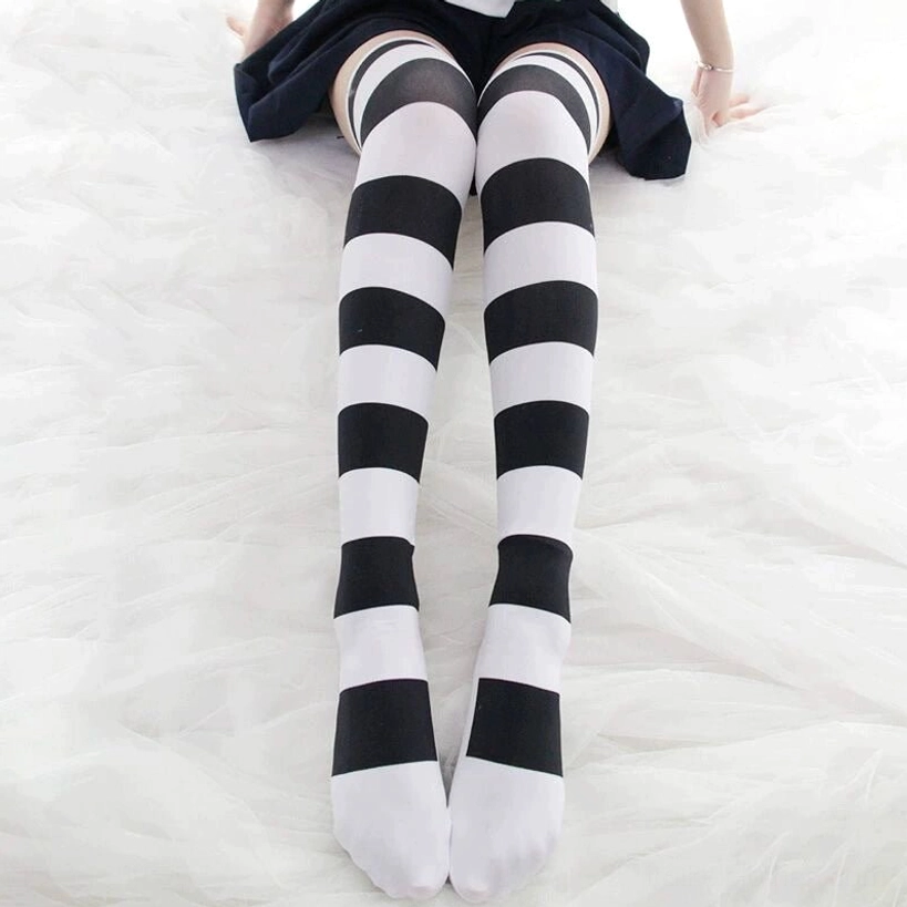 Black-white horizontal striped over-the-knee socks with reinforced heel on female model, dark mini skirt, classic Jirai Kei styling close-up