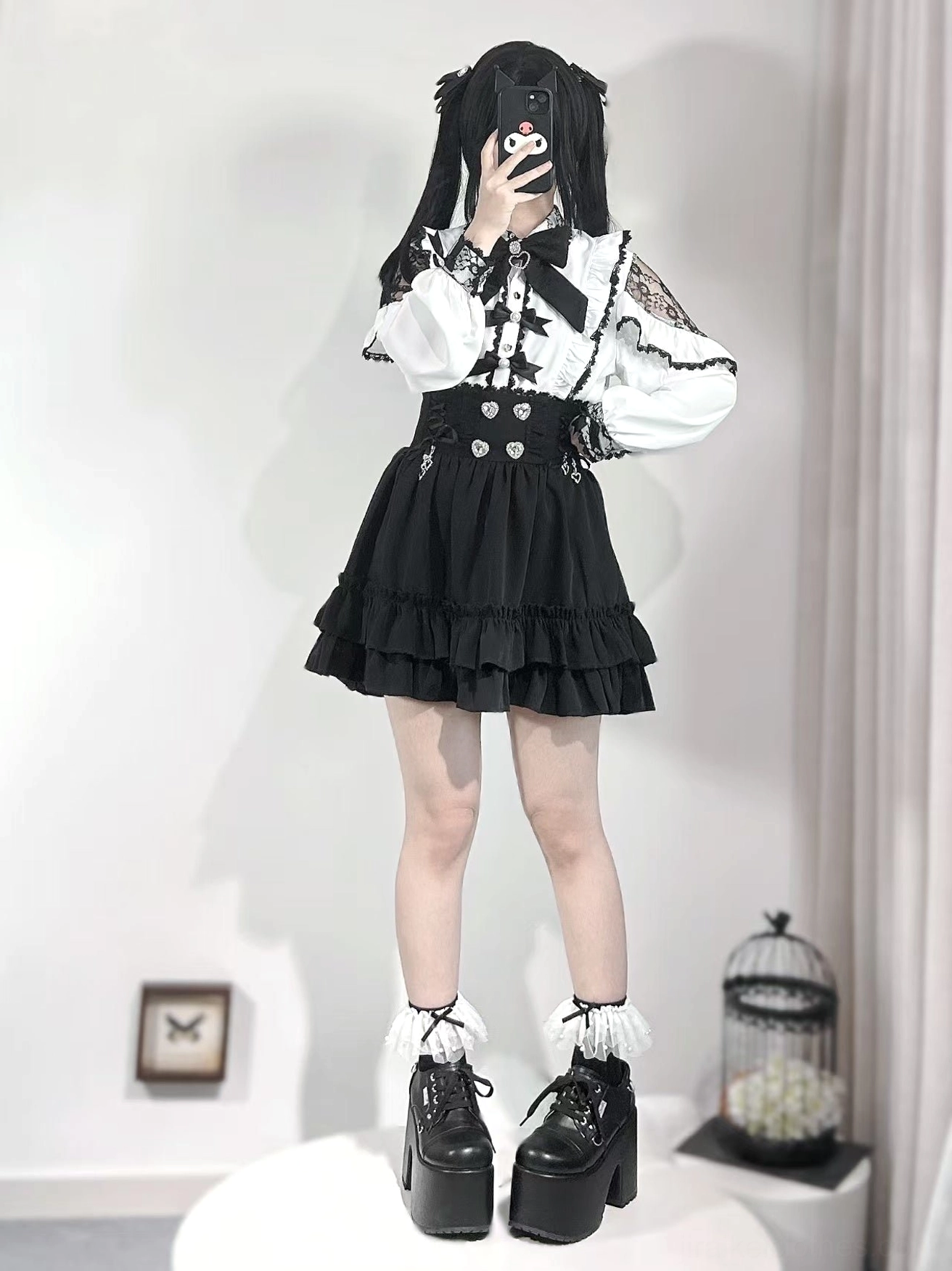 Jirai Kei back view showing white off-shoulder blouse with lace back shoulder panels, ruffled black skirt, platform boots, and black back bow tie detail