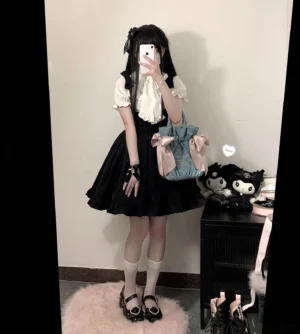 Full-body mirror selfie showcasing complete Jirai Kei two-piece outfit featuring white butterfly tie blouse, black ruffled suspender skirt, white crew socks, and Mary Jane shoes