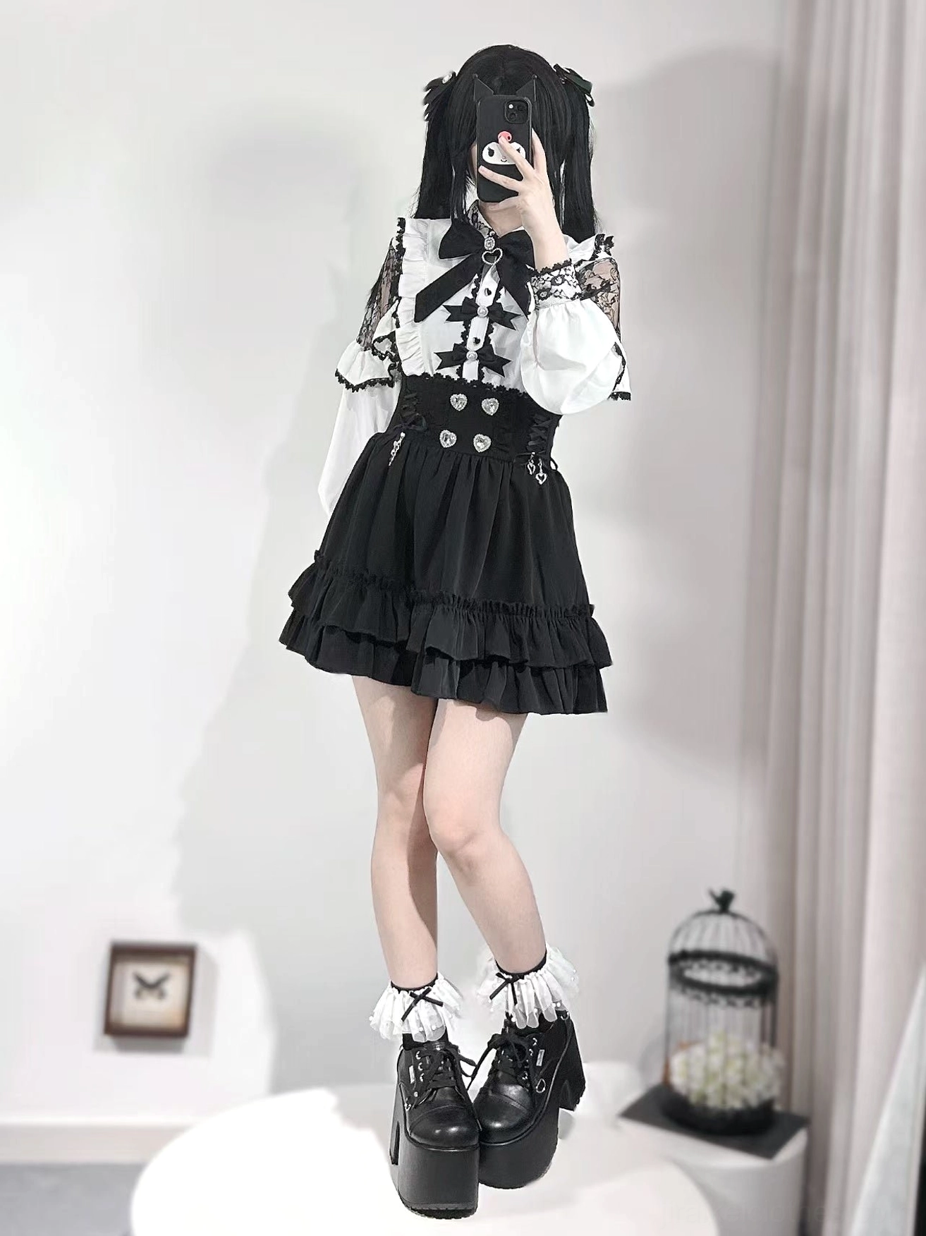 Jirai Kei outfit left side view displaying white off-shoulder lace blouse, crossed-leg pose, ruffled black skirt, platform boots, and frilly lace socks