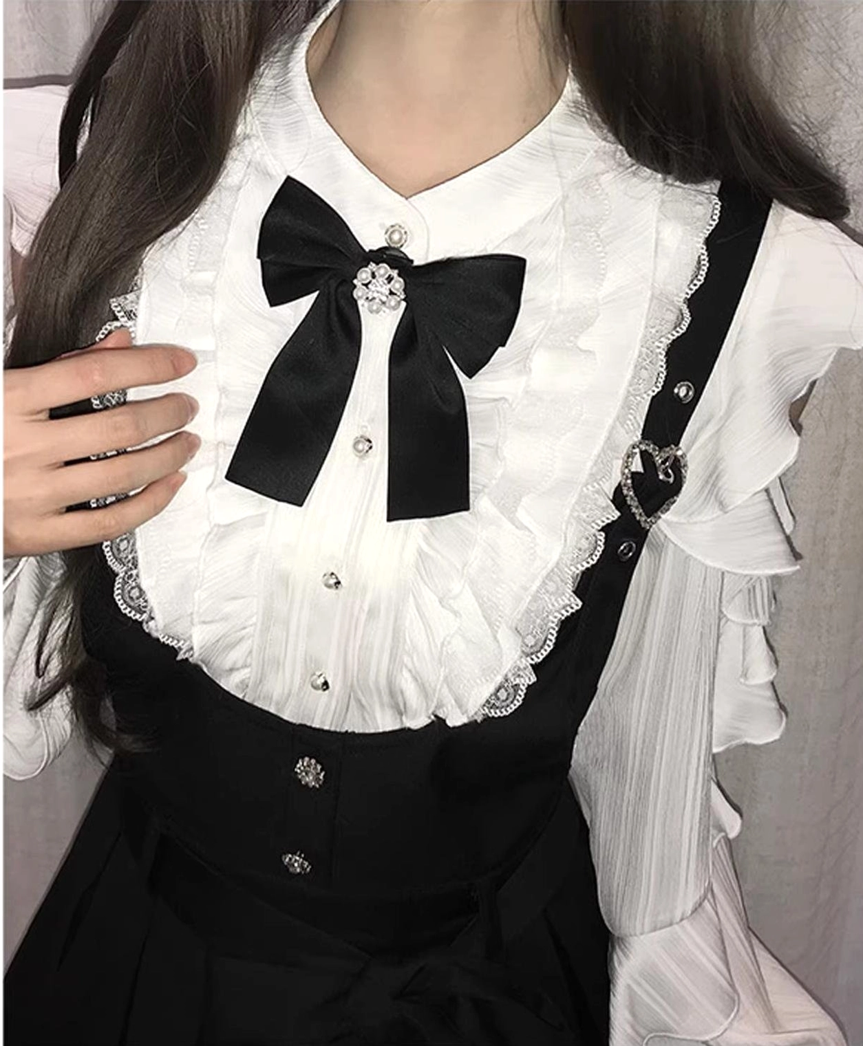 Jirai Kei outfit close-up detail lace-trimmed ruffles on off-shoulder shirt black bow with gem brooch heart-shaped suspender buckle