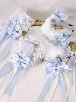 Blue Jirai Kei lace hair accessory set flat lay featuring satin bows feather clips and lace elements on gold decorative tray white background