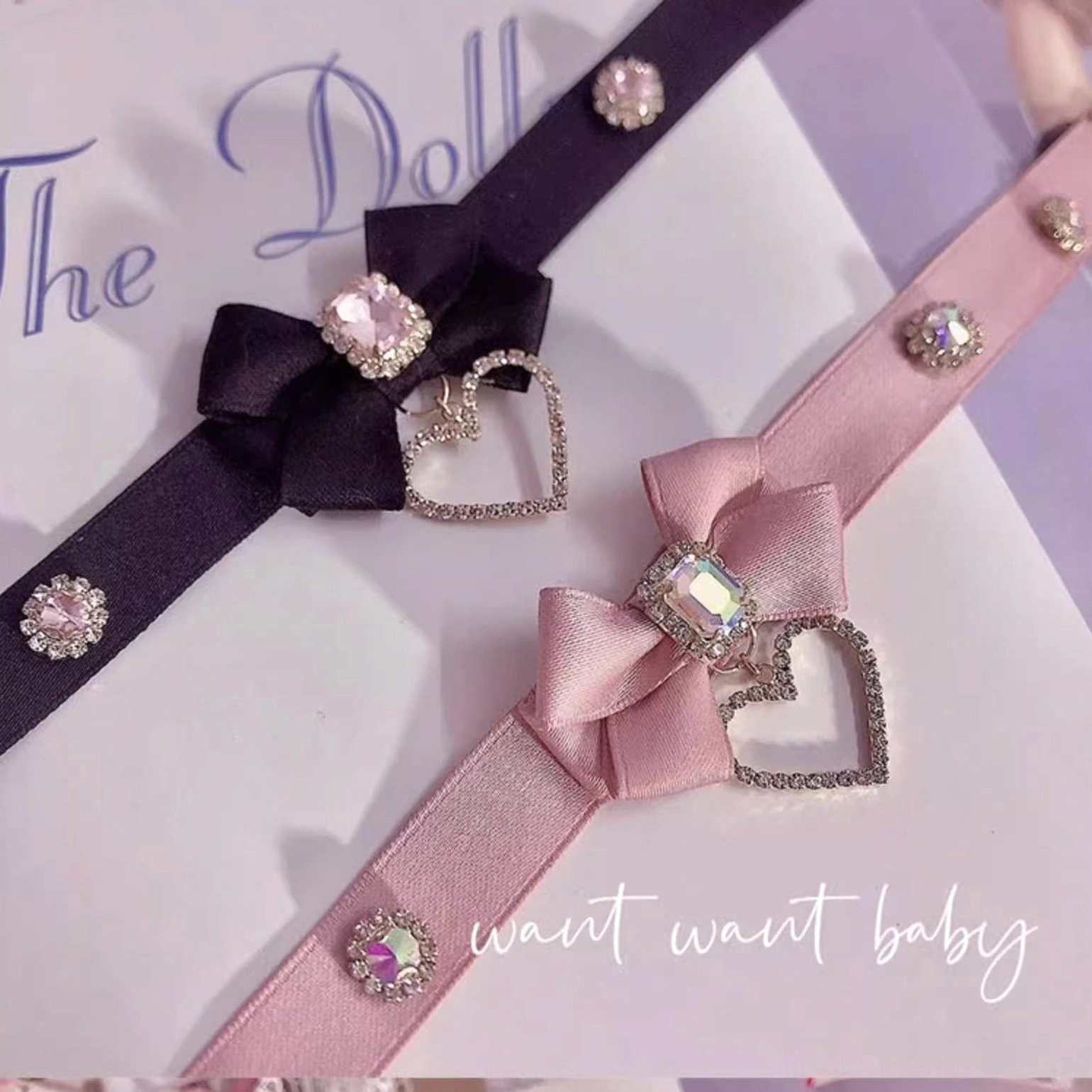 Handmade bow rhinestone choker necklace flat lay featuring delicate satin ribbon with sparkling cubic zirconia stones and heart-shaped pendant charm for Jirai Kei fashion aesthetic