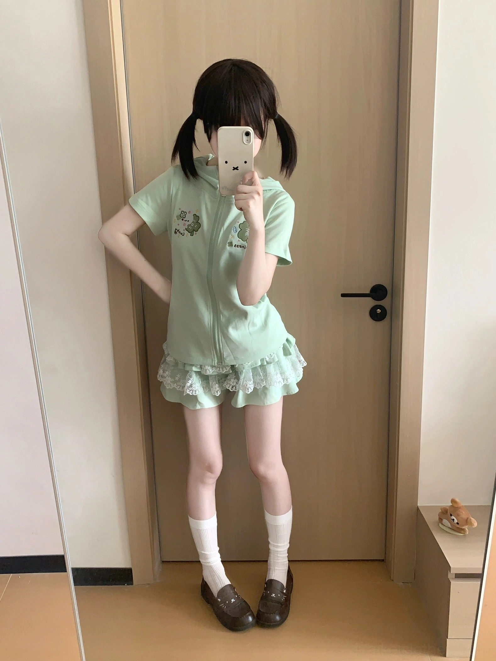 Mint green cute two-piece Jirai Kei set on model with hand-on-hip pose showing matching short-sleeve hoodie and tiered lace ruffle skirt with white socks and loafers