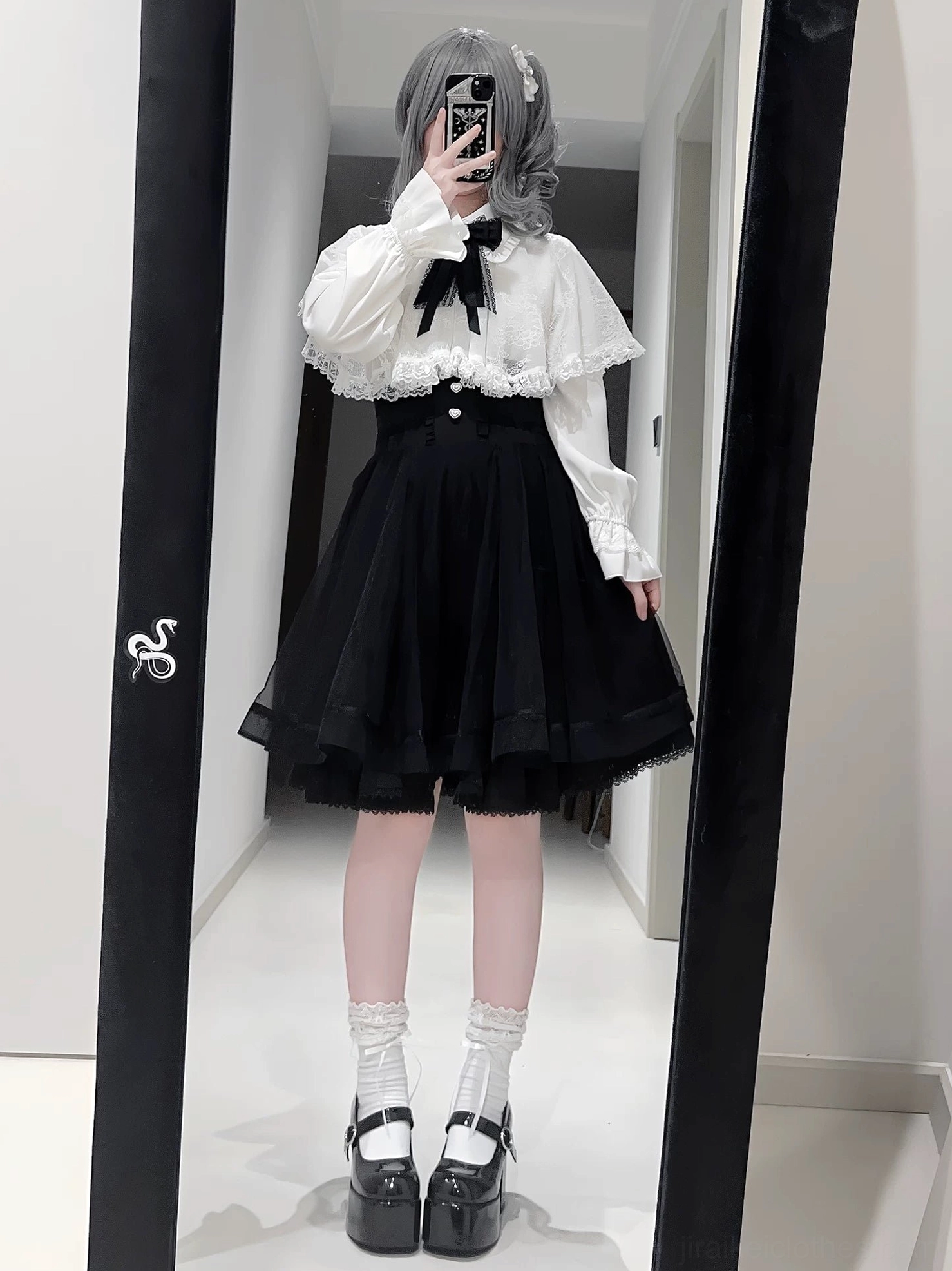 Classic black-white Jirai Kei lolita set with bow tie blouse, tiered black tulle skirt, platform Mary Jane shoes, grey hair model