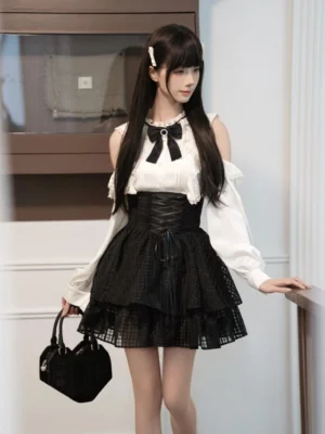 Cold-shoulder Jirai Kei blouse with removable black bow collar and high-waisted plaid ruffled skirt front three-quarter view