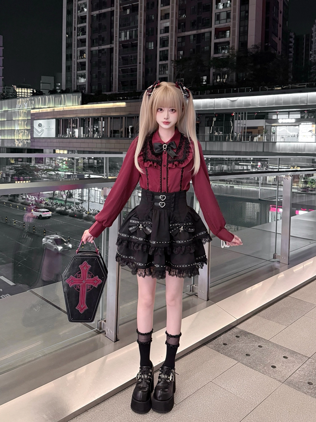 Full front-body view of complete Jirai Kei outfit displaying high-waisted black cake-style lace skirt, wine-red long-sleeved blouse, and platform loafers on nighttime commercial terrace